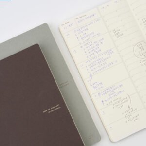 The view of the Analogue Keeper Space Diary in its two colours, brown and grey or beaver and elephant, and the inside view of the Space Diary, with some notes written in blue and black ballpoint.